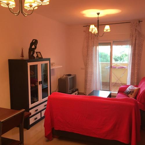 サンルーカル・デ・バラメダにあるPlaya de Las Piletasのリビングルーム(赤いベッド1台、テレビ付)