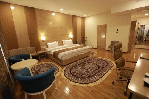 a hotel room with a bed and a table and chairs at Hotel Uzbekistan in Urganch