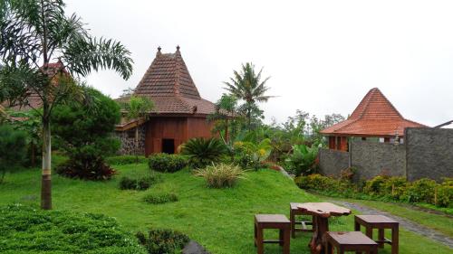 a house with a yard with tables and chairs at Villa Sindoro Village in Wonosobo