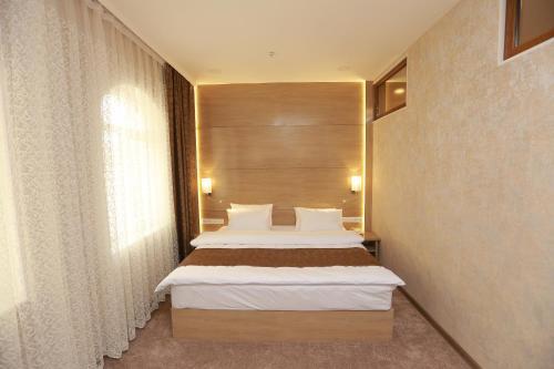 a bedroom with two beds and a large window at Hotel Uzbekistan in Urganch