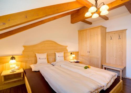 ein Schlafzimmer mit einem großen weißen Bett mit zwei Lampen in der Unterkunft Parggenhof in Innichen