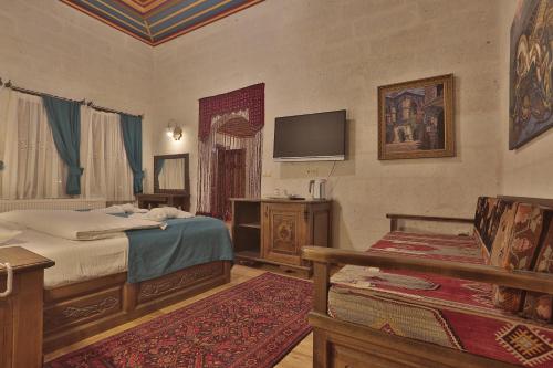 a bedroom with a bed and a tv on the wall at Yoruk Stone House in Nevsehir