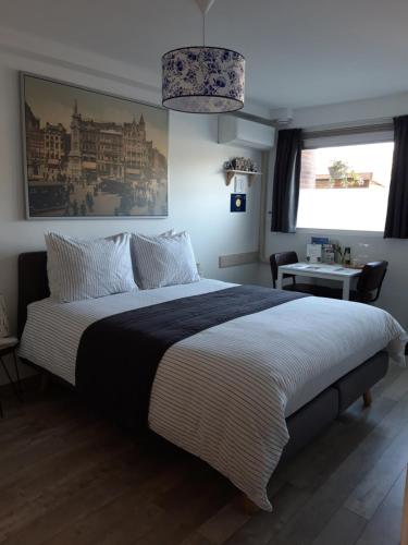 een slaapkamer met een groot bed en een zwart-witte deken bij JamieK's BnB in Amsterdam