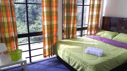 a bedroom with a bed and a large window at EZ Lodgings in Kampong Gadong
