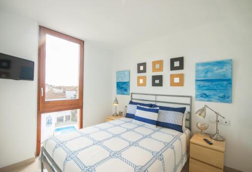 ein weißes Schlafzimmer mit einem Bett und einem Fenster in der Unterkunft Lets Holidays Estrella Pelegri 2 in Tossa de Mar