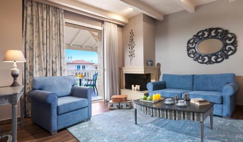 a living room with two blue chairs and a table at Kyniska Palace Conference & Spa in Mystras