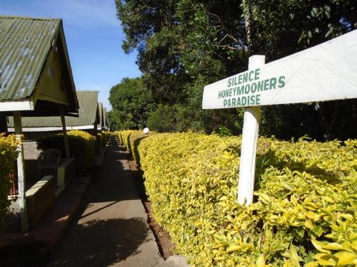 a sign in a hedge with a sign for a garden at Rhino Tourist Camp in Ololaimutiek