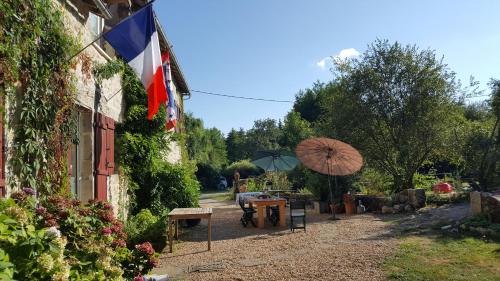 a flag and an umbrella next to a building at Le Moulin de Pensol - Gites in Pensol