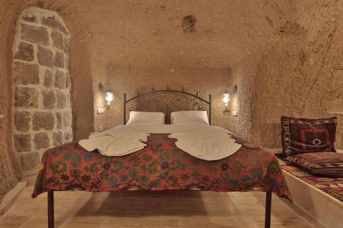 a bedroom with a large bed in a stone room at Yoruk Stone House in Nevsehir