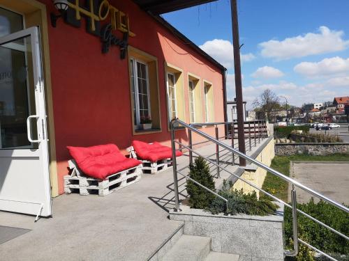 a porch with two red pillows on a building at Hotel Gryf in Kościerzyna