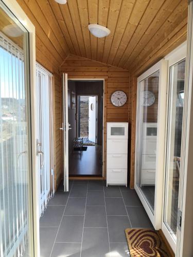 a hallway of a house with a clock on the ceiling at Kuvågen 23 in Vågenes