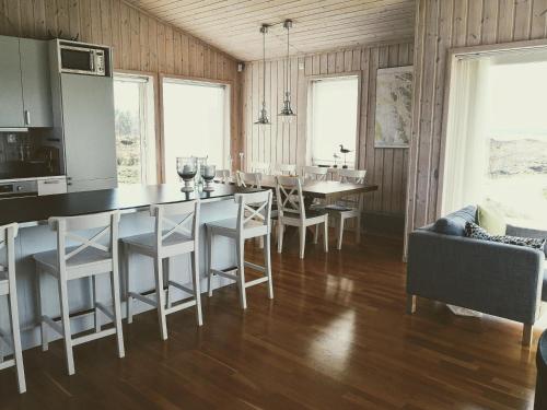 a kitchen and dining room with a table and chairs at Kuvågen 23 in Vågenes