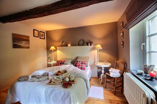 Un dormitorio con una cama con una bandeja de comida. en Gîte Le Charme du Passé en Havelange