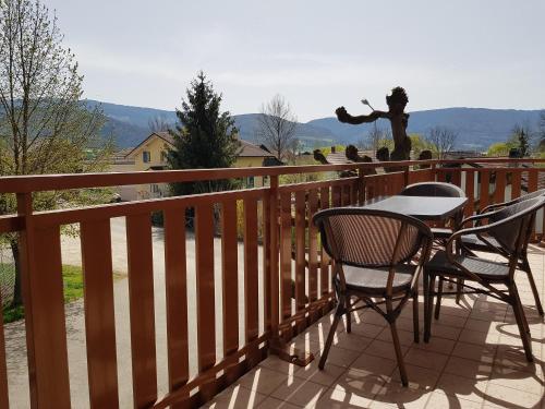 a table and chairs on a balcony with a view at Apartement-Gîte rural à 3 km de Delémont in Courcelon