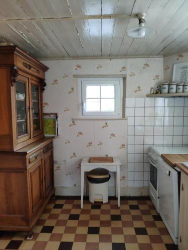 eine kleine Küche mit einem Tisch und einem Fenster in der Unterkunft Maison d'Argonne in Brécy-Brières