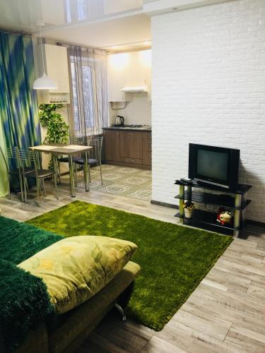 a living room with a couch and a tv and a table at Двухкімнатна студія in Chernihiv