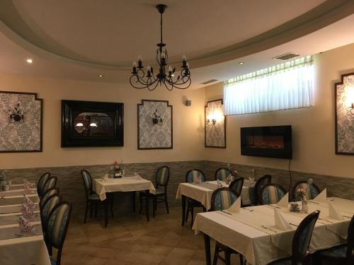 a dining room with tables and chairs and a chandelier at Guest House Veronika in Kočevje