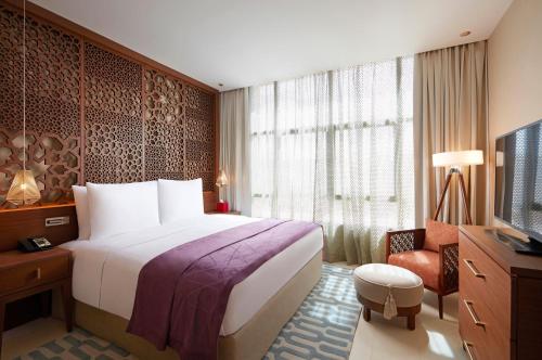 a hotel room with a bed and a television at Tilal Riyadh in Riyadh