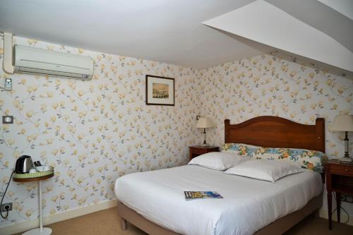 a bedroom with a bed and a wall covered in flowers at Chateau de la Rozelle in Cellettes