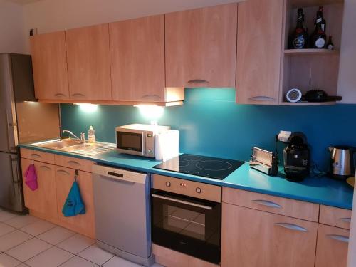 a kitchen with a microwave and a stove top oven at A 100 m de la mer et du port ! Parking privatif ! in Fécamp