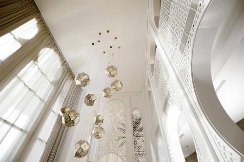 a white room with a chandelier and windows at Shaza Riyadh in Riyadh