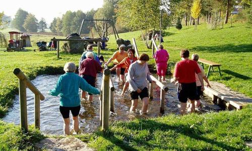 a group of people walking through a creek at Blockhäuser Stamsried in Stamsried