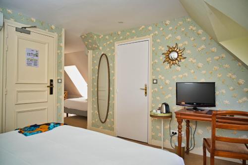 a bedroom with a bed and a desk and a television at Chateau de la Rozelle in Cellettes