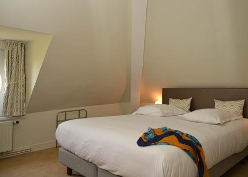 a bedroom with a large white bed and a window at Chateau de la Rozelle in Cellettes