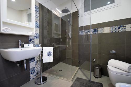 a bathroom with a shower and a sink and a toilet at DELPOSTO Marina di Ragusa PRL in Marina di Ragusa