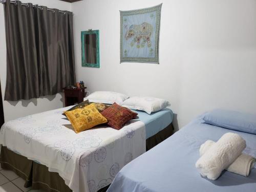 a room with two beds with pillows on them at Ap Completo a 5min Centro Eventos/10min praias in Itajaí