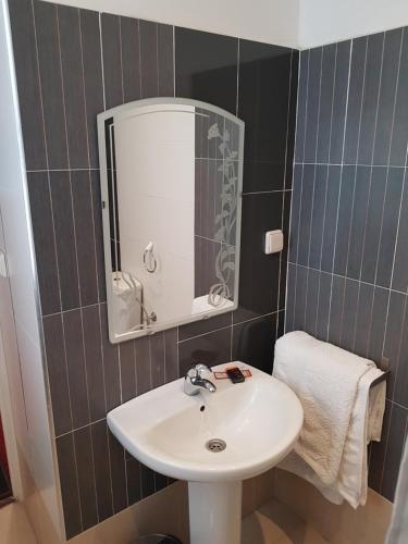 a bathroom with a sink and a mirror at Ambassy Hotel in Kenitra