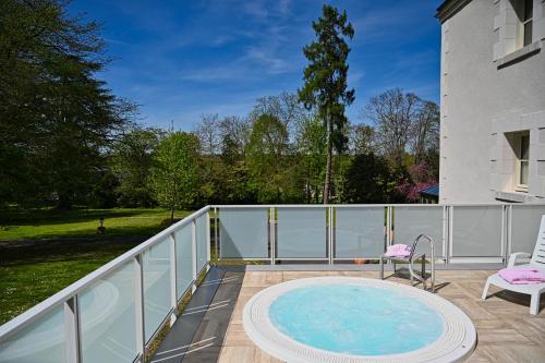 a balcony with a hot tub and a chair at Chateau de la Rozelle in Cellettes