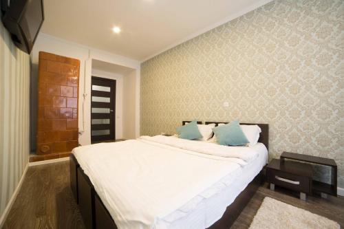 - une chambre avec un grand lit blanc et des oreillers bleus dans l'établissement Staroievreiska Apartments, à Lviv