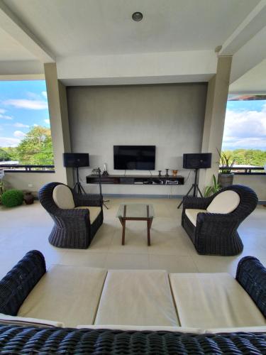 a living room with two chairs and a flat screen tv at Felicidad Resto and Pension House in General Santos