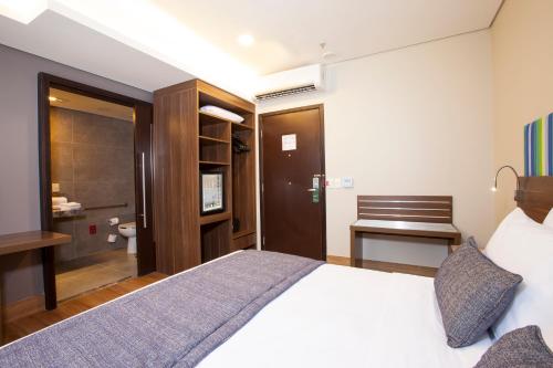 a hotel room with a bed and a bathroom at Prodigy Santos Dumont by Wish in Rio de Janeiro