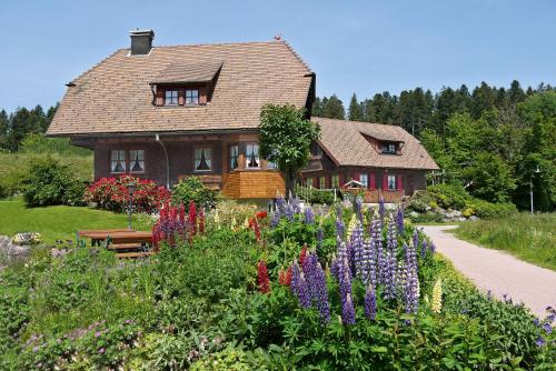 uma casa com um jardim com flores em frente em Landhaus Anja em Freudenstadt