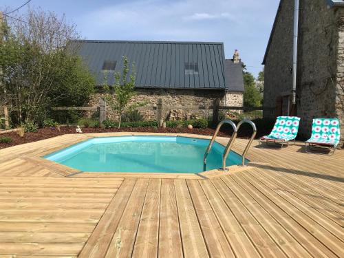 - une piscine sur une terrasse en bois avec 2 chaises dans l'établissement La Grange, à Saint-Calais-du-Désert