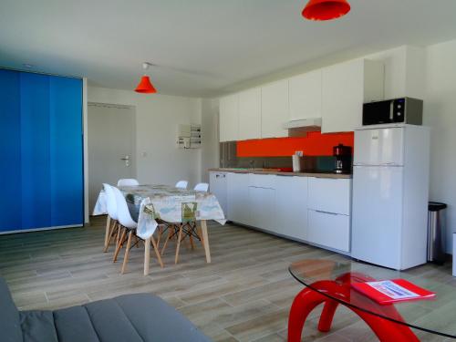 une cuisine et une salle à manger avec une table et des chaises dans l'établissement Residence du Fou, à Trévou-Tréguignec