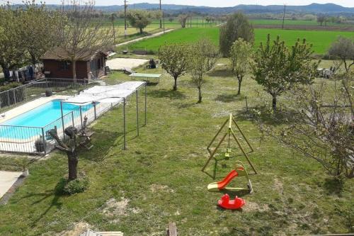 une aire de jeux extérieure avec une piscine et une balançoire dans l'établissement Le Lou Mazet 1951, à Saint-Nazaire-des-Gardies