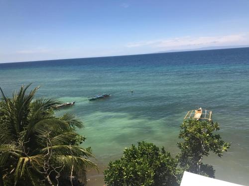 a view of the ocean with boats in the water at Babylon Oslob Coast Guesthouse in Oslob