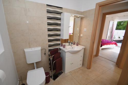 La salle de bains est pourvue d'un lavabo et de toilettes. dans l'établissement Apartment LIBRA with sea view, à Opatija
