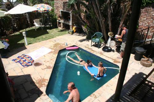 three people playing in a swimming pool with a frisbee at Myoli Beach Lodge in Sedgefield