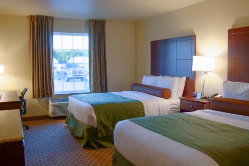 a hotel room with two beds and a window at Cobblestone Inn & Suites-Winterset in Winterset