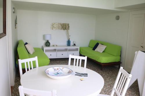 a living room with a table and green chairs at Casa Vacanza Anacapri Sunrise in Anacapri