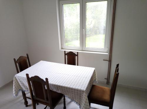 een tafel en stoelen met een tafel en een raam bij Apartman Miljkovic in Arandjelovac