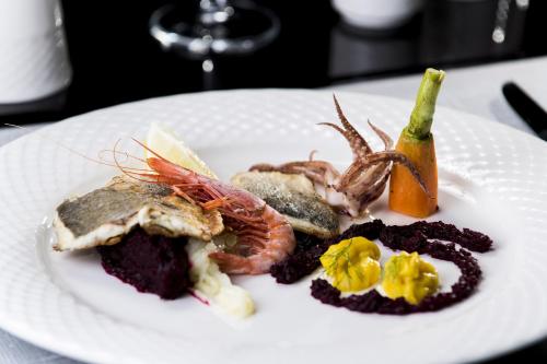 a plate of food with seafood on a table at Hotel Best Night in Alger