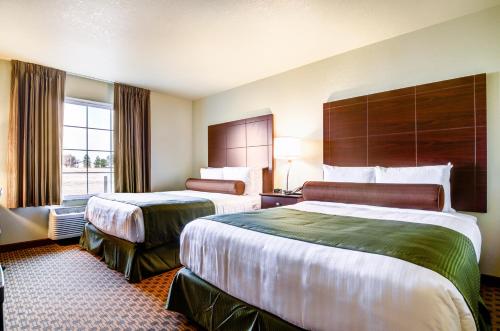 um quarto de hotel com duas camas e uma janela em Cobblestone Inn & Suites-Winterset em Winterset