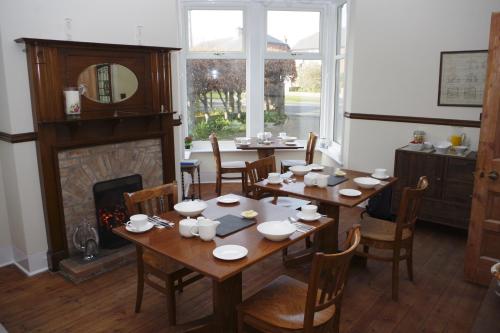 een eetkamer met een tafel en een open haard bij The Coal Merchant's House in Whitby