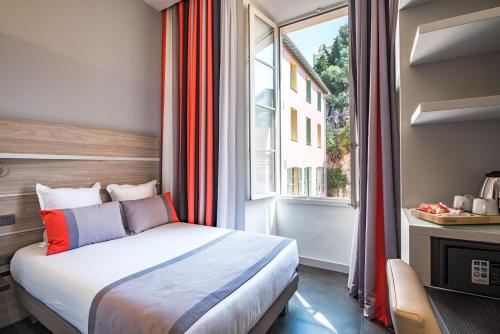 a hotel room with a bed and a window at Hotel Le Saint Paul in Nice