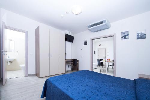ミザーノ・アドリアーティコにあるRabbit Homeの白いベッドルーム(青いベッド1台、デスク付)